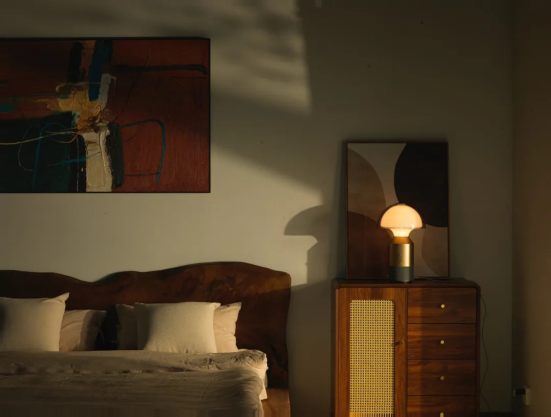 Actual SOLA Halo Sound photograph: illuminated glass dome, metal body, physical controls and textile speaker base on a timber cabinet