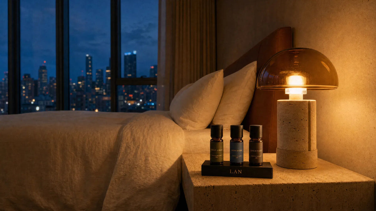 A bedroom scene with scent compositions beside a warm table lamp